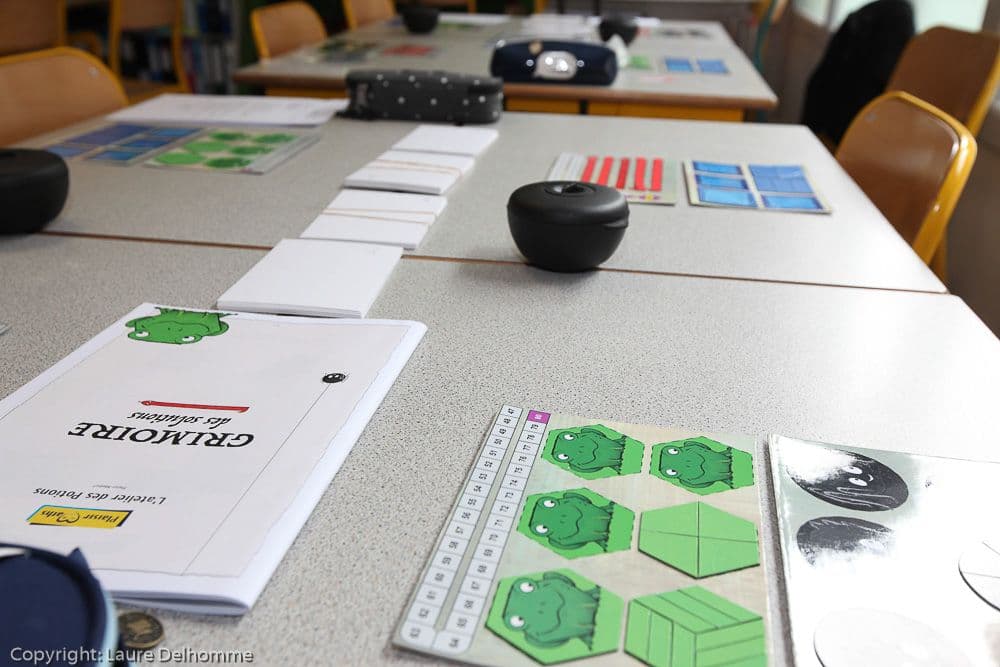 Le grimoire des solutions posé sur une table de classe